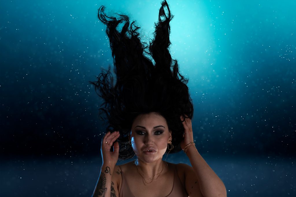 Deafmetal tekee kuulolaitteista korujen näköisiä, jolloin ne ikäänkuin katoavat näkösälle. Tämä kuva näyttää vedenalaiskuvalta, mutta on kuvattu sisätiloissa. 